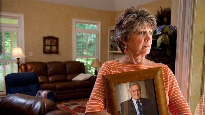 George McAfee’s daughter holds a photo of her father, who died after swallowing toxic dishwashing liquid at an Emeritus facility in Georgia