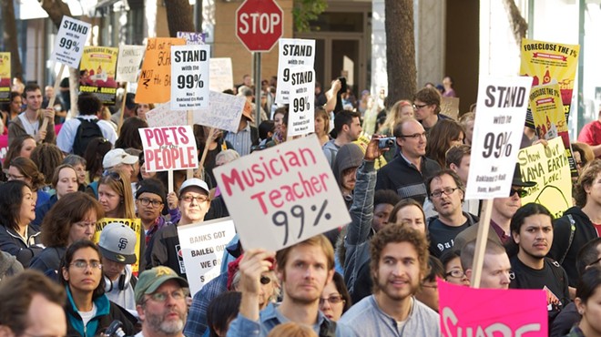 Protestors carry "We are the 99 percent" signs during an Occupy protest in 2011.