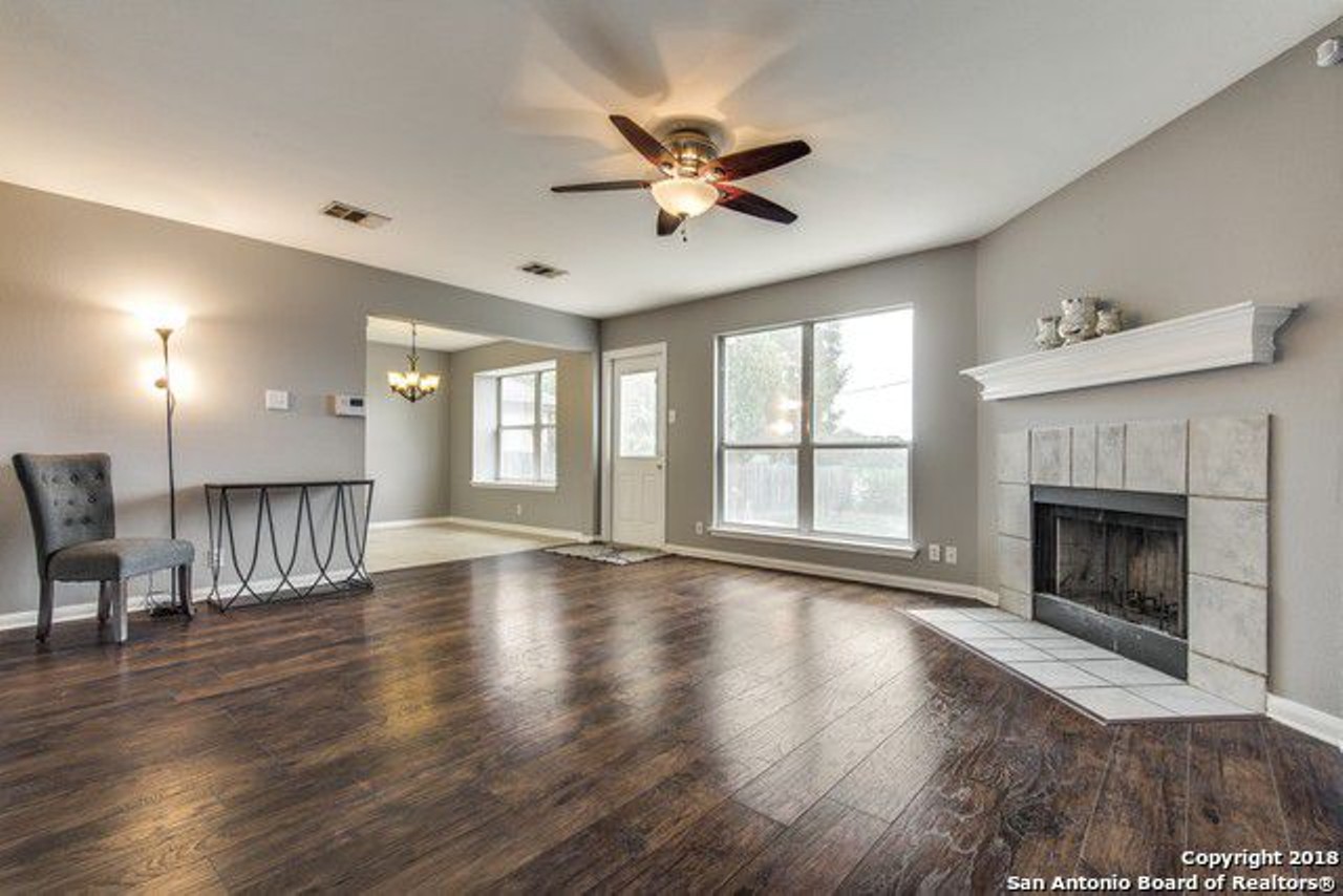 The spacious living room has gorgeous wood floors and a cozy fireplace.