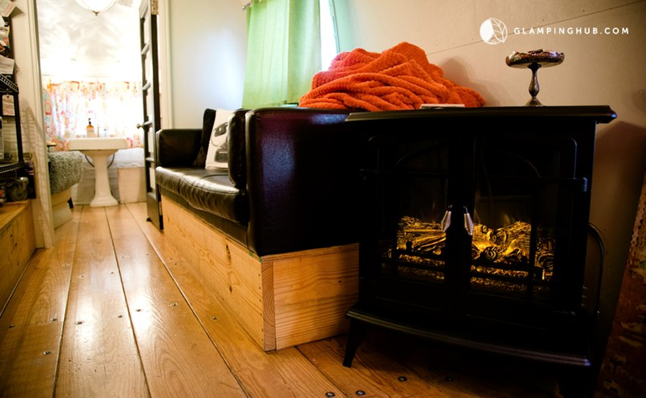 A small fireplace can be found in the living room area, ready to warm guests with its embers.
