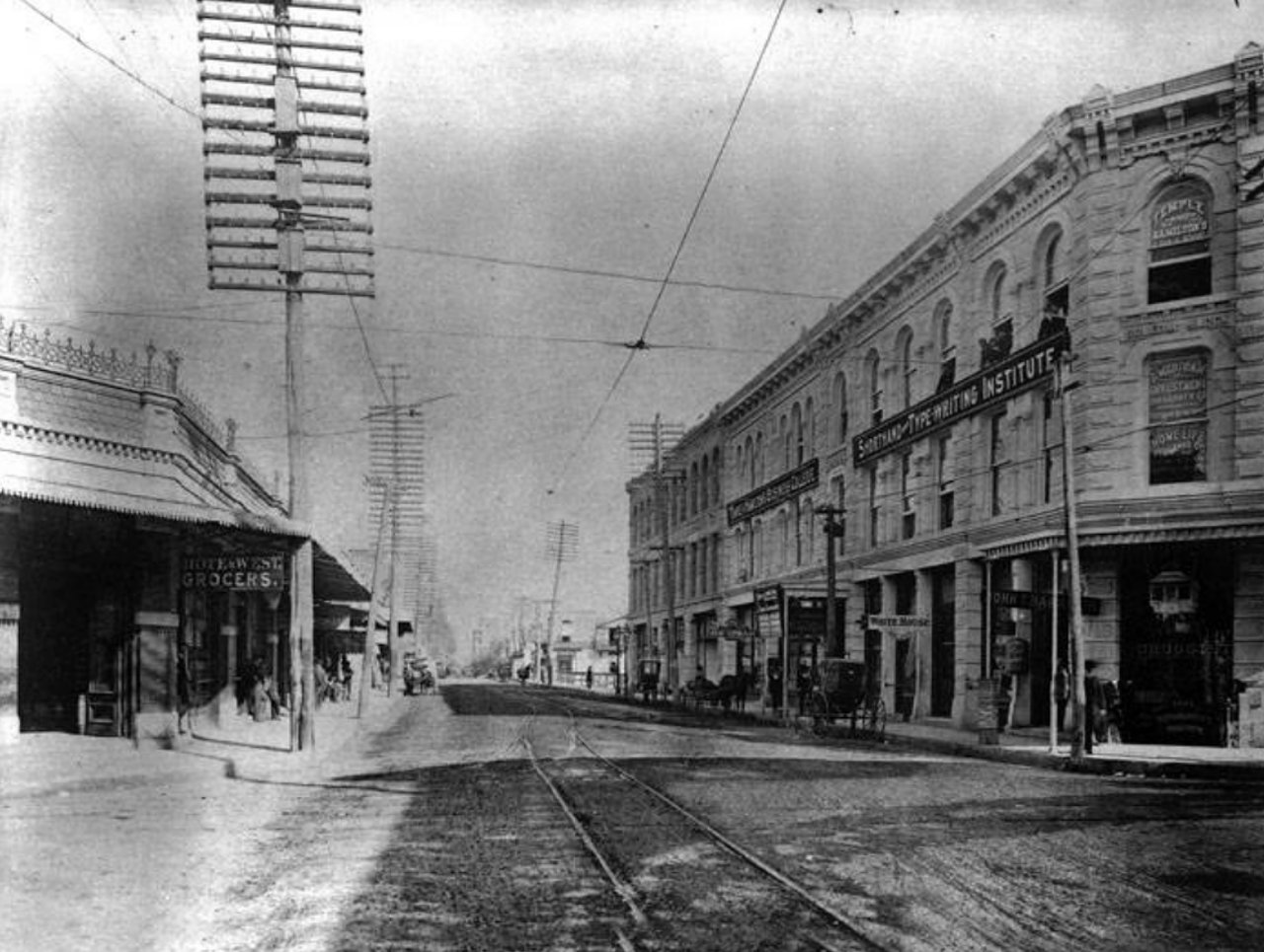 Back in the 1890s, West Houston Street housed the Rote and West Grocers, which can be seen on the left. Across the street was the three-story Soledad Block.