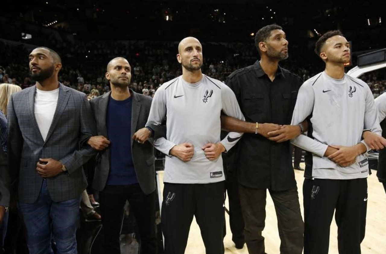 Current and past players stood on the court in solidarity after the National Anthem as the message was displayed.