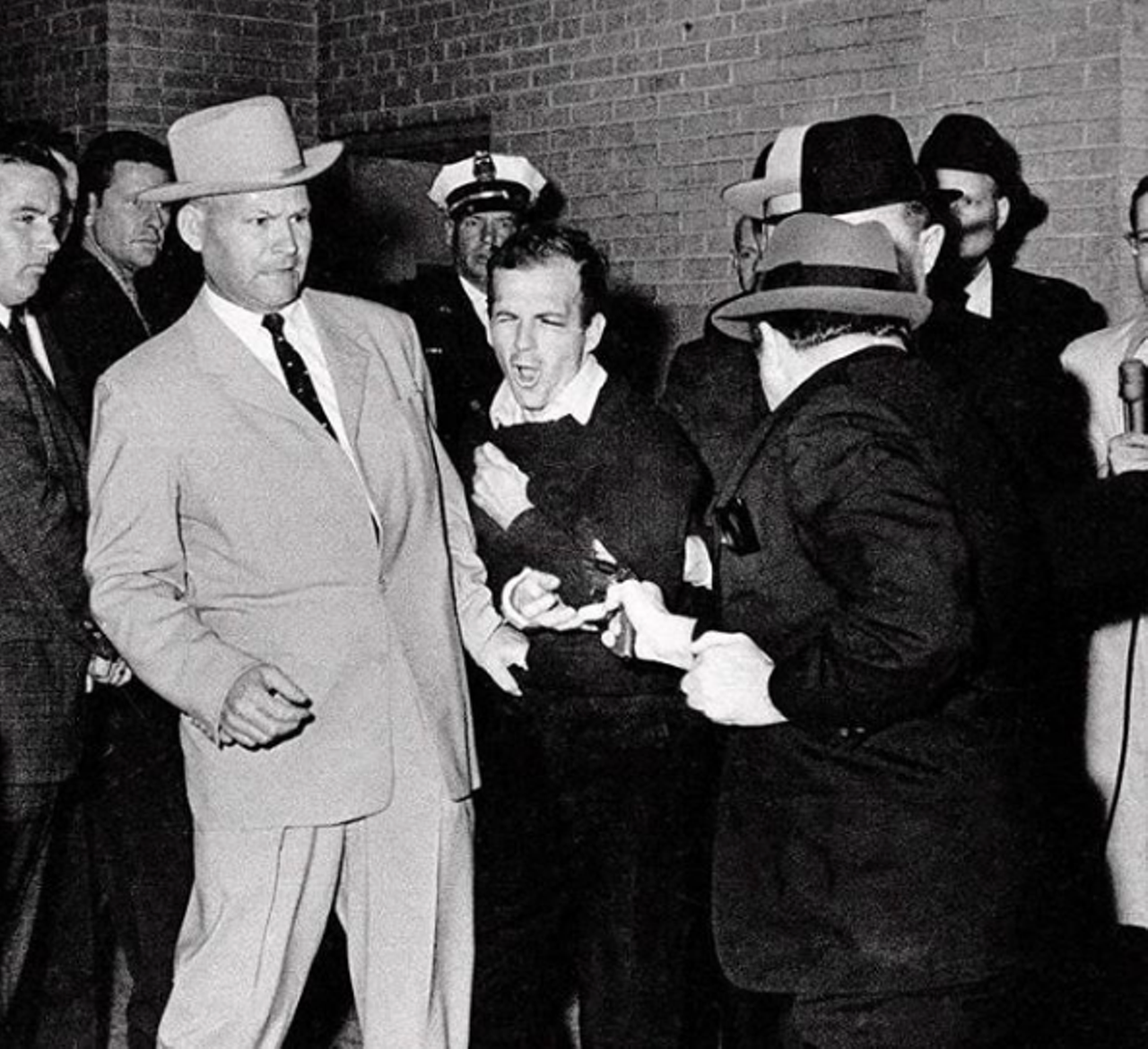 Lee Harvey Oswald
Lee Harvey Oswald is definitely not famous for a good reason. If you haven’t already heard his name, you’ll read why in a sec. Lee Harvey Oswald was considered a loner for most of his life and dropped out of school at around 15 or 16. After joining the military, he was court-martialed twice, once for keeping a private weapon without permission and the other for assaulting an NCO. After he was discharged, he would go on to be the accused assassin of JFK and later shot and killed on live TV shortly thereafter. He is buried in Fort Worth at Shannon Rose Hill Memorial Park.
Photo via Bob Jackson / Dallas Times Herald