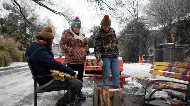 From left: Martin Xoxa, Chelsea Pursley and Joe Williams build a fire on Thursday to keep warm outside of Pursley's home in East Austin. The group had been without power since Monday evening.