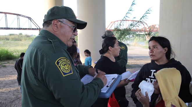 U.S. Border Patrol agents talk to asylum seekers who crossed into South Texas near Eagle Pass.