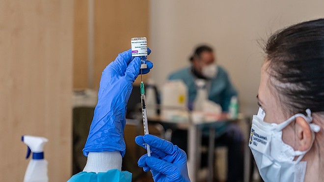 A health worker draws a syringe full of AstraZeneca's COVID-19 vaccine.