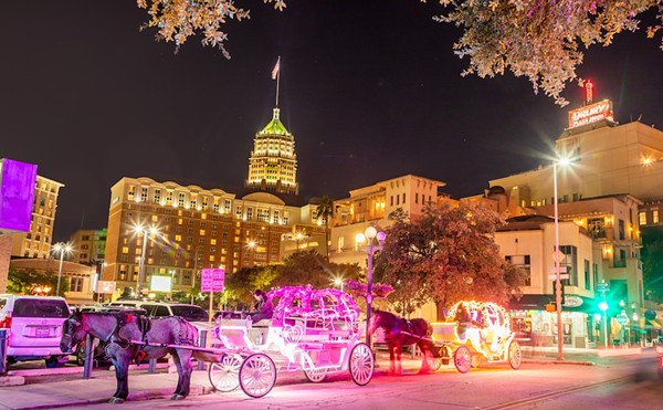 Horse drawn carriages line up at night in downtown San Antonio.