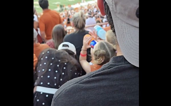 A child chugs from a red and blue tallboy during the Texas Longhorns football game on Saturday.