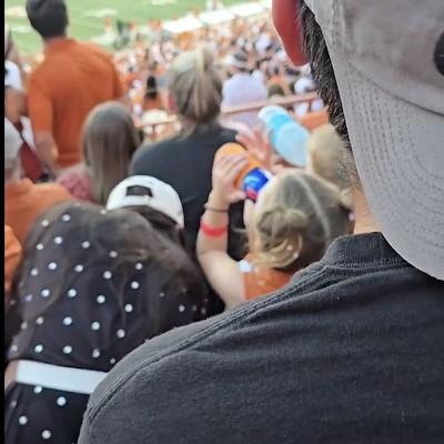 A child chugs from a red and blue tallboy during the Texas Longhorns football game on Saturday.