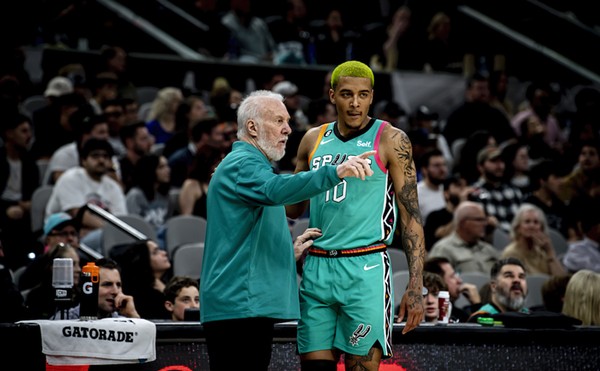 Spurs foward Jeremy Sochan talks to Hall of Fame coach Gregg Popovich before going into a game.