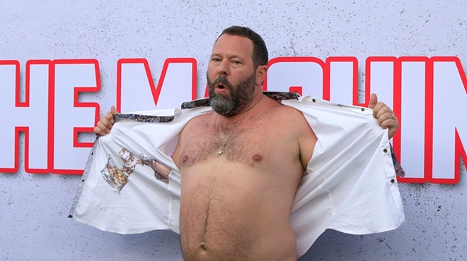 Bert Kreischer shows his chest at the premiere of his movie The Machine at the Village Theater in Westwood, Calif.