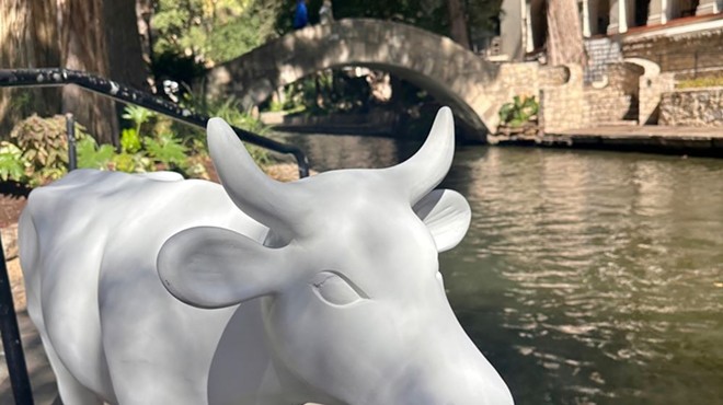 An unpainted CowParade sculpture stands on the San Antonio River Walk.