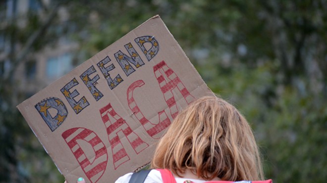 A protester holds a sign showing support for Deferred Action for Childhood Arrivals.