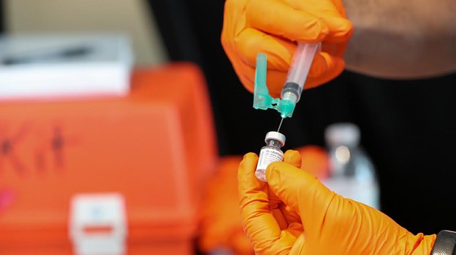 A health worker at a San Antonio vaccination site fills a syringe.