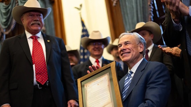Gov. Greg Abbott poses with a framed letter from the Sheriffs Association of Texas at the Texas Capitol in Austin on Wednesday, March 20, 2024.