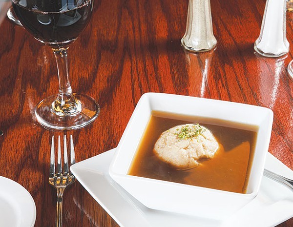 A single dumpling floats atop an honest bouillon soup - WWW.PAYTONPHOTOGRAPHY.COM
