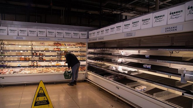 A customer looks through nearly empty shelves inside a Central Market grocery store in Austin on Feb. 17, 2021.