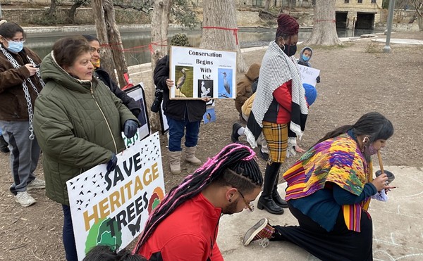 District 2 City Councilman Jalen McKee-Rodriguez kneels as Native American activists conduct a ceremony during a protest against San Antonio's effort to cut down trees inside Brackenridge Park.
