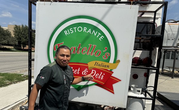 Owner Filiberto Torres poses in front of the sign from the original Fratello's, which he now displays on the back of his Broadway food truck.