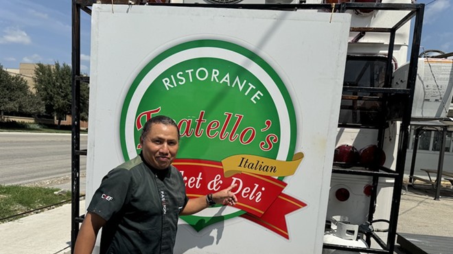 Owner Filiberto Torres poses in front of the sign from the original Fratello's, which he now displays on the back of his Broadway food truck.