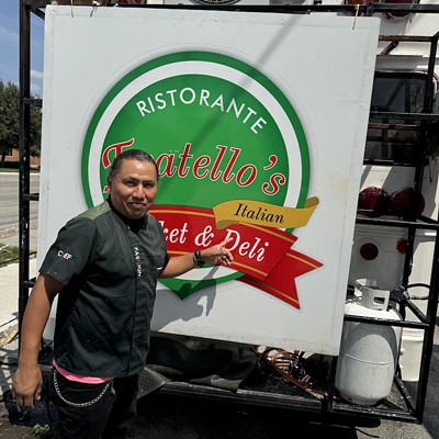 Owner Filiberto Torres poses in front of the sign from the original Fratello's, which he now displays on the back of his Broadway food truck.