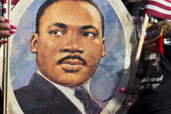 A participant in the 2014 MLK Day March in San Antonio holds up an image of Dr. Martin Luther King, Jr. - Rick Canfield
