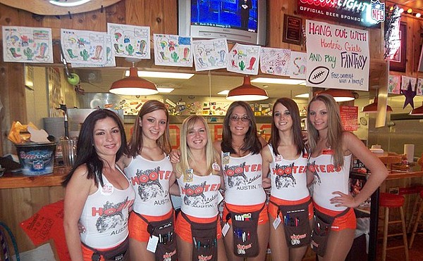 Staffers at a Hooters store show off the skimpy attire the chain is known for.