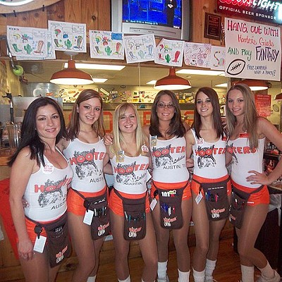 Staffers at a Hooters store show off the skimpy attire the chain is known for.