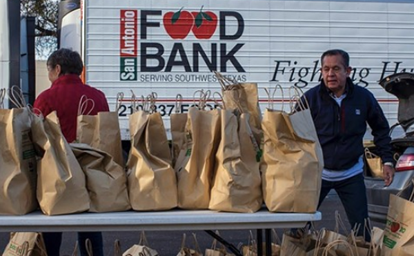 San Antonio Food Bank workers hand out consumables during a distribution event.