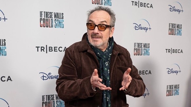 Elvis Costello talks with hands at an appearance to promote the 2022 music documentary If These Walls Could Sing.