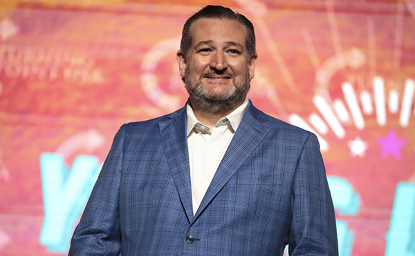 U.S. Sen. Ted Cruz smirks from the stage at a speaking event.