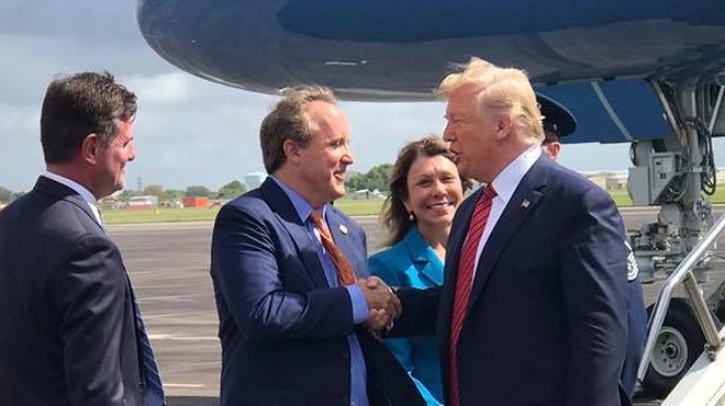 Texas AG Ken Paxton (center) meets President Donald Trump on the Tarmac during a 2019 presidential visit to Houston.