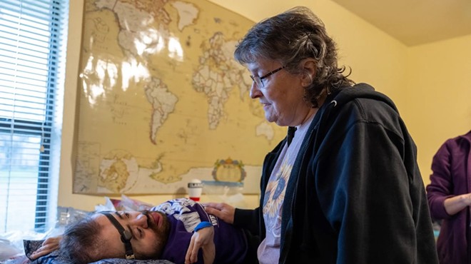 Debbie Wiederhold talks with her 31-year-old son Daniel at their home in Hutto on Feb. 29, 2024. Though Daniel was born with a rare brittle bone disorder, he lives an active life with support from state services.