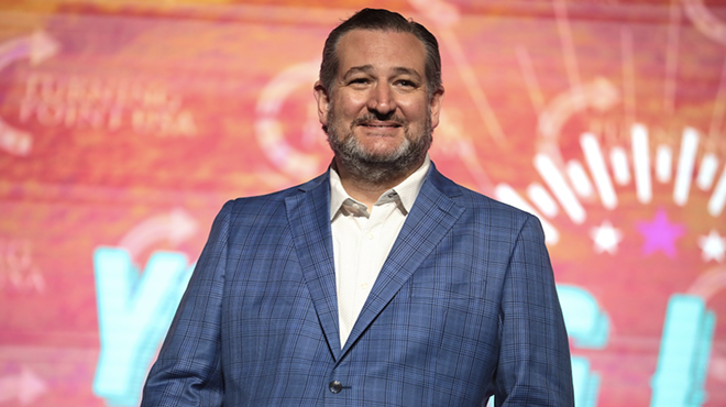 U.S. Sen. Ted Cruz smirks from the stage at a speaking event.