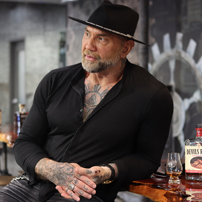 Actor Dave Bautista (left) stands next to a glass of Devils River Whiskey.