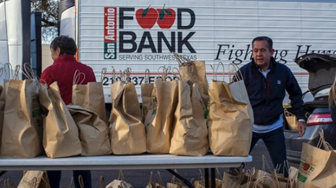 San Antonio Food Bank workers hand out consumables during a distribution event.