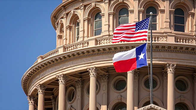 The Texas and United States flag billow in the wind at the Texas State Capitol in Austin.