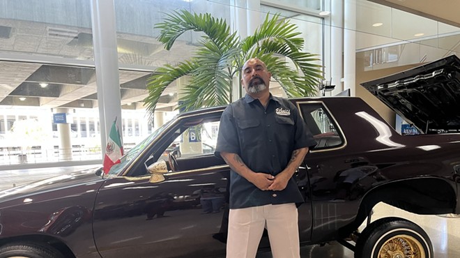 Arturo DeHoyos shows off his 1986 Oldsmobile Cutlass Supreme, which is part of the new lowrider exhibition at San Antonio International Airport.