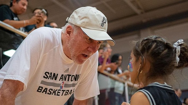Coach Gregg Popovich interacts with a young fan during Saturday's practice in Uvalde.