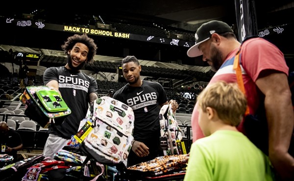 Spurs players hand out backpacks at last year's Back to School Bash.