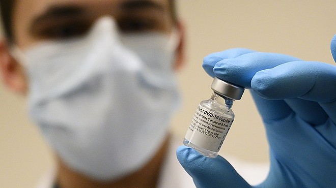 A medical professional holds a vial of the COVID-19 vaccine.
