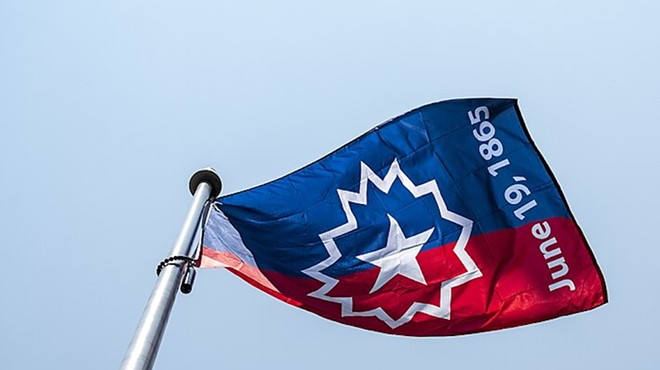 A Juneteenth flag waves in the wind during a 2023 ceremony.