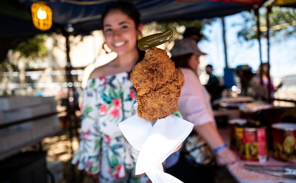 A vendor serves chicken on a stick at Oyster Bake 2023.