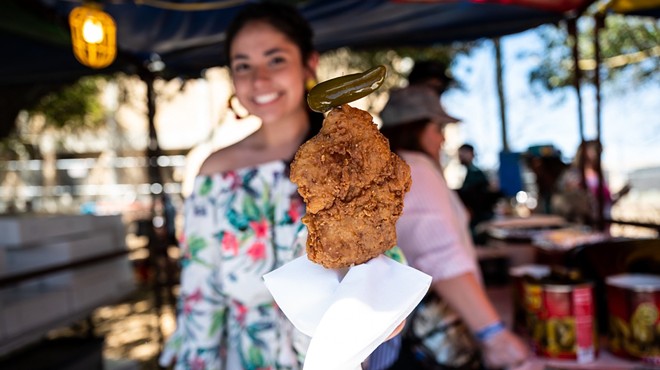 A vendor serves chicken on a stick at Oyster Bake 2023.