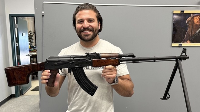 Congressional candidate Brandon Herrera holds up a replica Romanian RPK his campaign is raffling off.