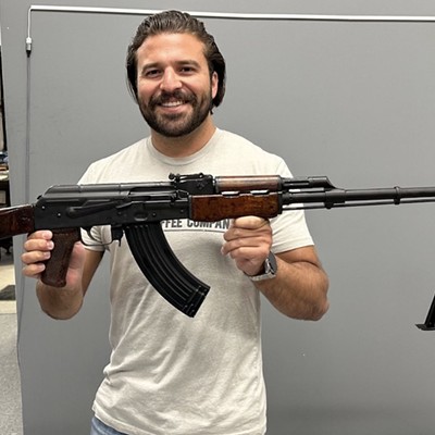 Congressional candidate Brandon Herrera holds up a replica Romanian RPK his campaign is raffling off.