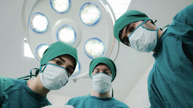 Medical professionals undertake a surgery.