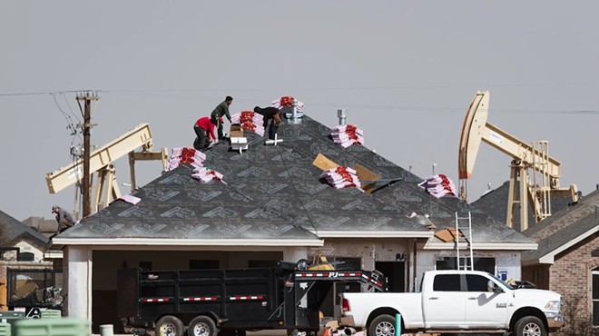 A roofing crew begins to shingle a home under construction in the Pavilion Park development in north Midland on March 14, 2022.