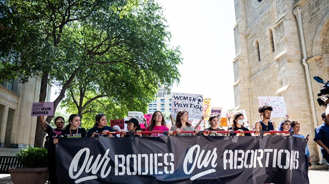 Women carry a banner through Downtown San Antonio during a protest defending abortion rights.