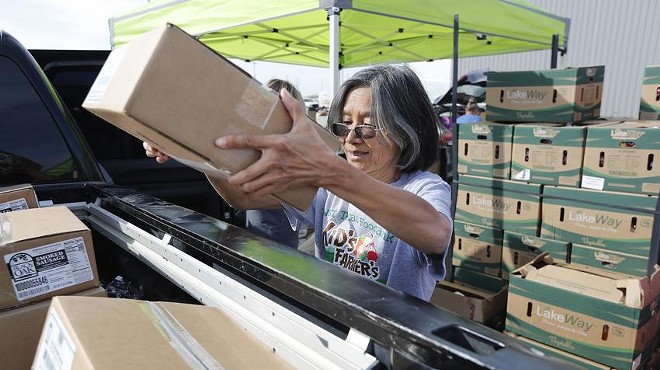 Yuchih Choy loads boxes of food into a pickup at the West Texas Food Bank in Odessa on Oct. 5, 2022.
